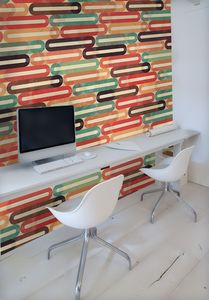 הקיר האלמנטים האובלים בכתום, חום וטורקיז על רקע לבן.