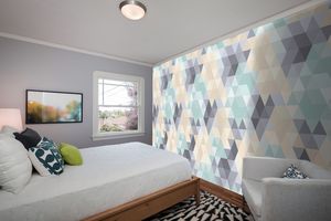 קיר גאומטרי משולשים בגוונים בהירים.